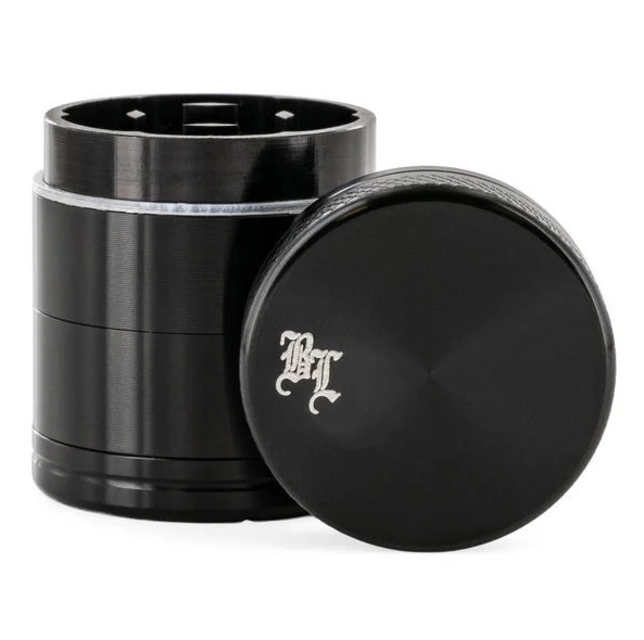 Black metal grinder with a black leaf logo on top. side view
