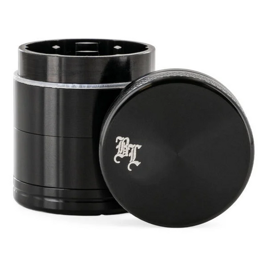 Black metal grinder with a black leaf logo on top. side view