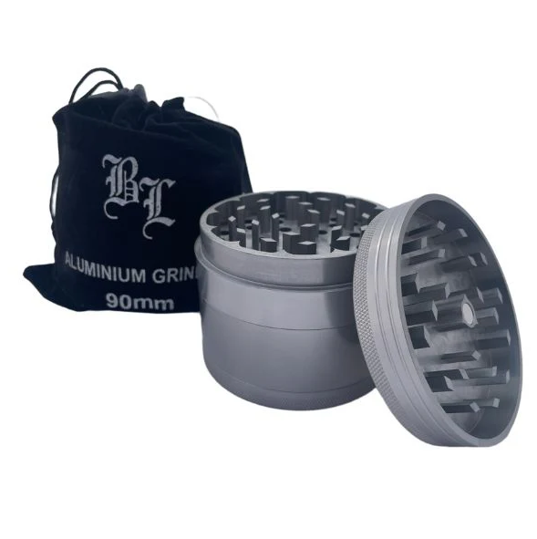 Aluminium grinder with open top and black drawstring bag on a white background